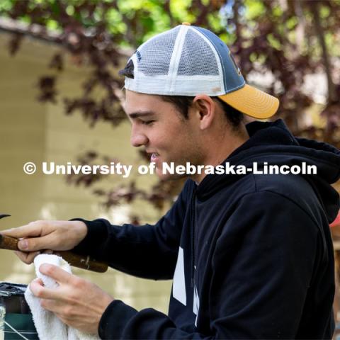 Ethan Bichler of Pi Kappa Alpha replaces the lid of a paint can during the Big Event. May 4, 2024. Photo by Kirk Rangel for University Communication.